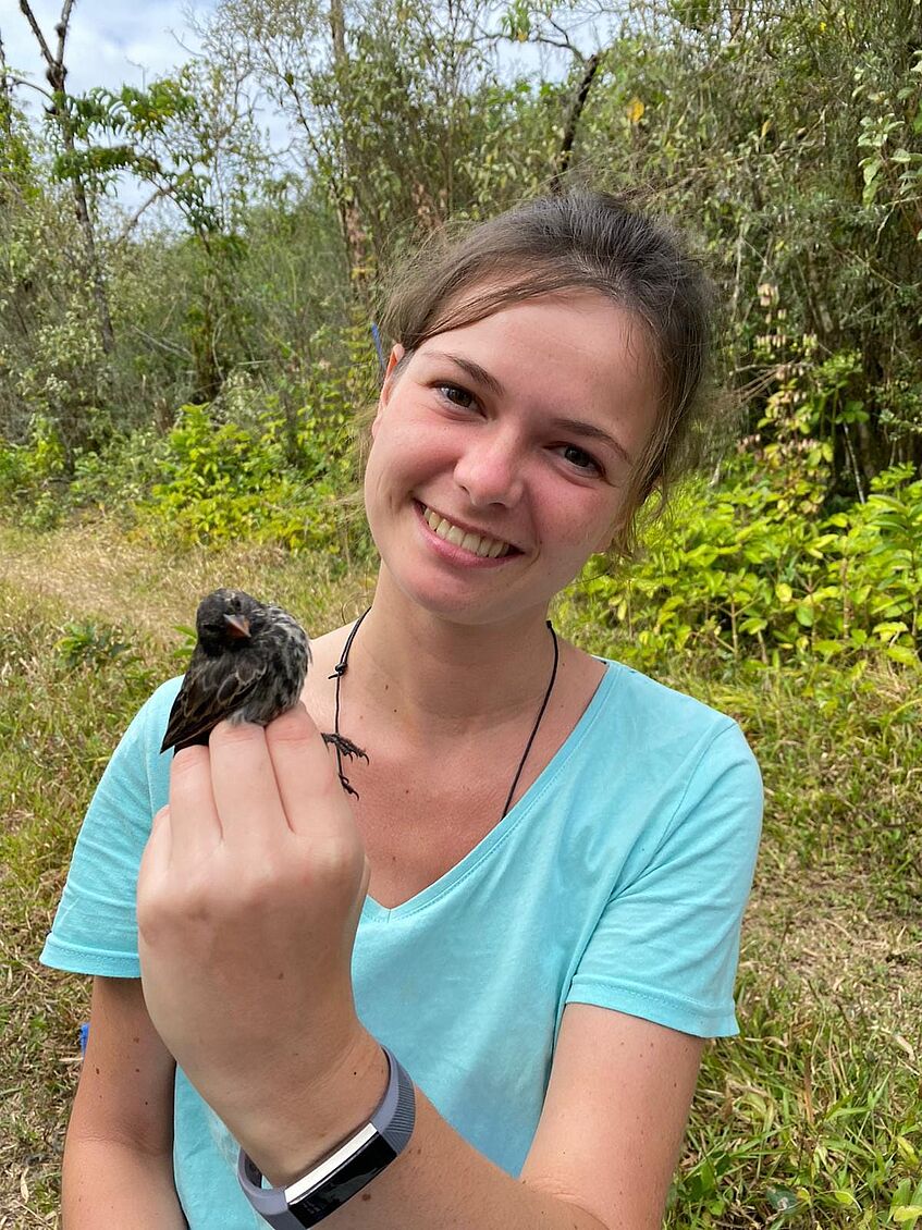portrait of young female scientist holding a small bird