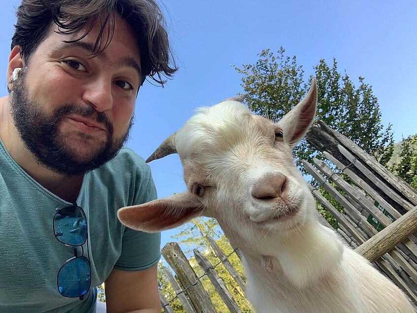 young man posing with a goat