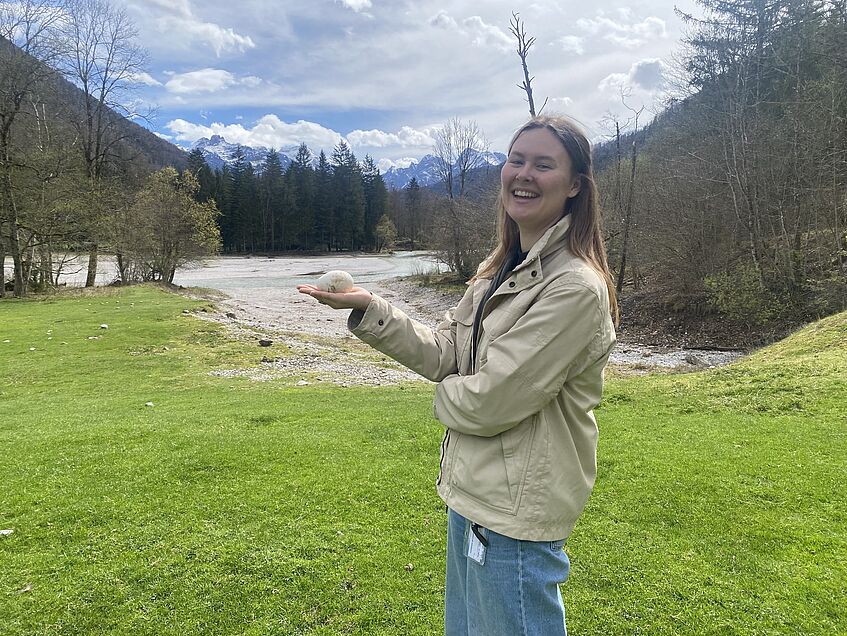 A female scientist presenting a goose egg in her hand