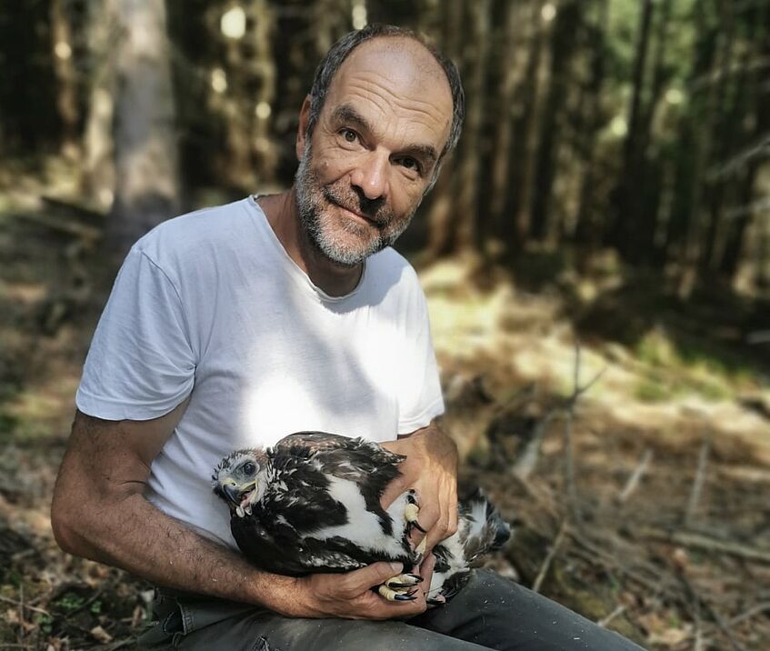 Ein Mann hält einen Adler